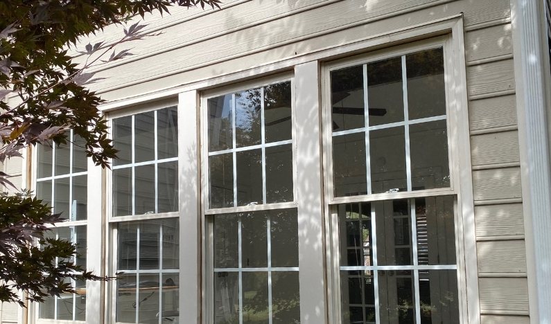 Before: a bank of old white grid windows with worn frames and dated muntin bars.