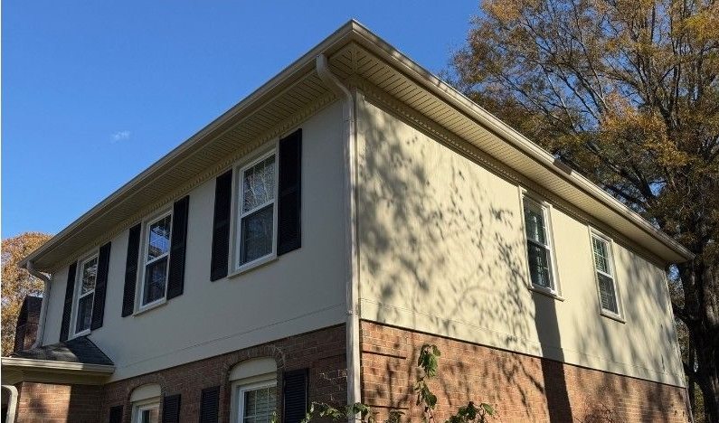 After: the finished corner, cream siding meeting the original red brick.
