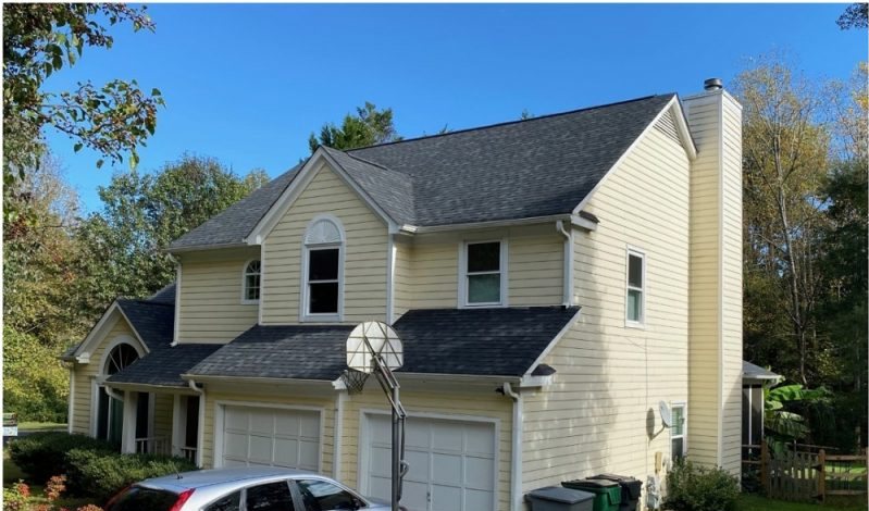 Before: a cream two-story with two garage doors and a silver car on the drive.