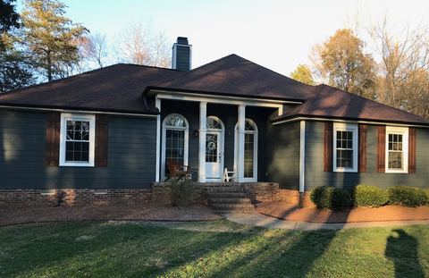 Single-story home refreshed with blue-gray siding, white porch columns and red shutters