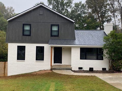 Painted white brick lower level with dark gray board-and-batten siding above