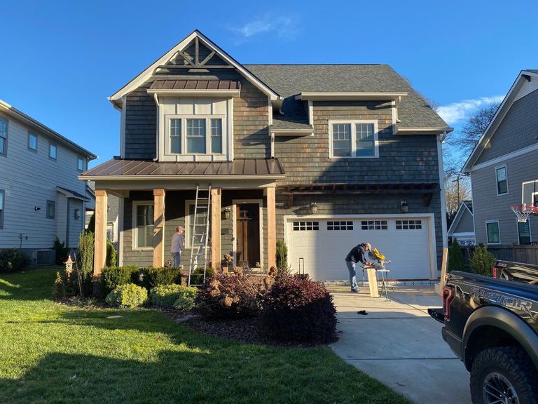 Craftsman home with tapered porch columns during exterior finishing work