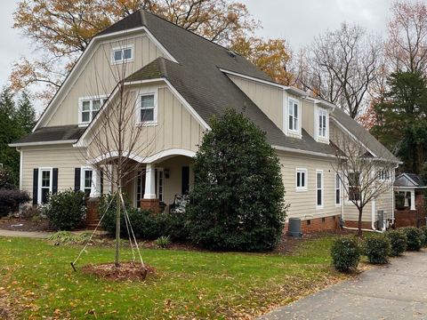 Cream craftsman-style home with dormer windows and white replacement windows