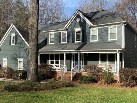 Gray two-story home with white porch railings after siding and window replacement