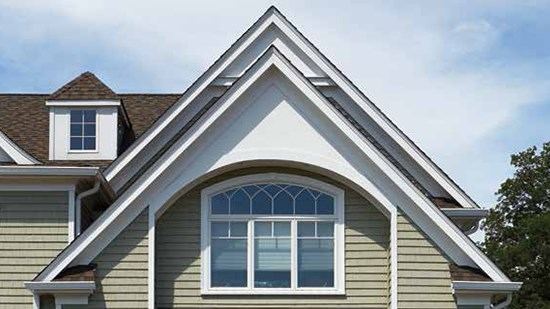 Gable end with an arched accent window and shingle-style siding detail