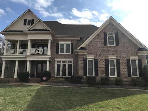 Two-story Ballantyne home in brick and siding with white double-hung replacement windows