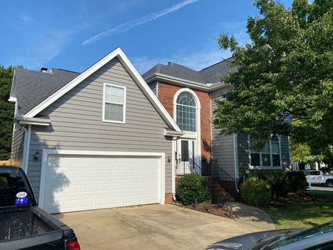 Tan insulated vinyl siding paired with brick on a two-story home