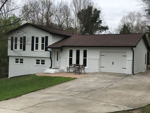 White-sided split-level home with a brown roof and attached garage
