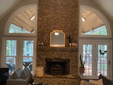 Interior great room with arched windows flanking a stone fireplace