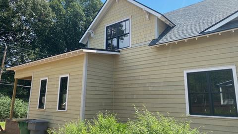 Cream fiber cement lap siding and black-framed windows on a two-story addition