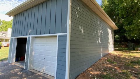 Detached garage clad in blue board-and-batten siding