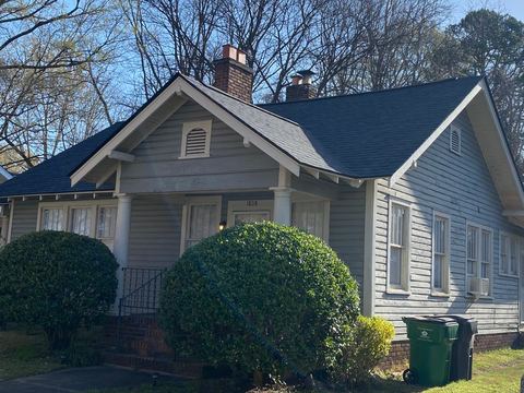 Craftsman bungalow with gray siding and a dark shingle roof