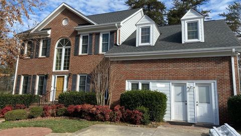 Red brick two-story home with white dormers and a yellow front door