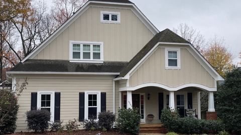 Tan lap siding with white trim and black shutters on a craftsman-style home